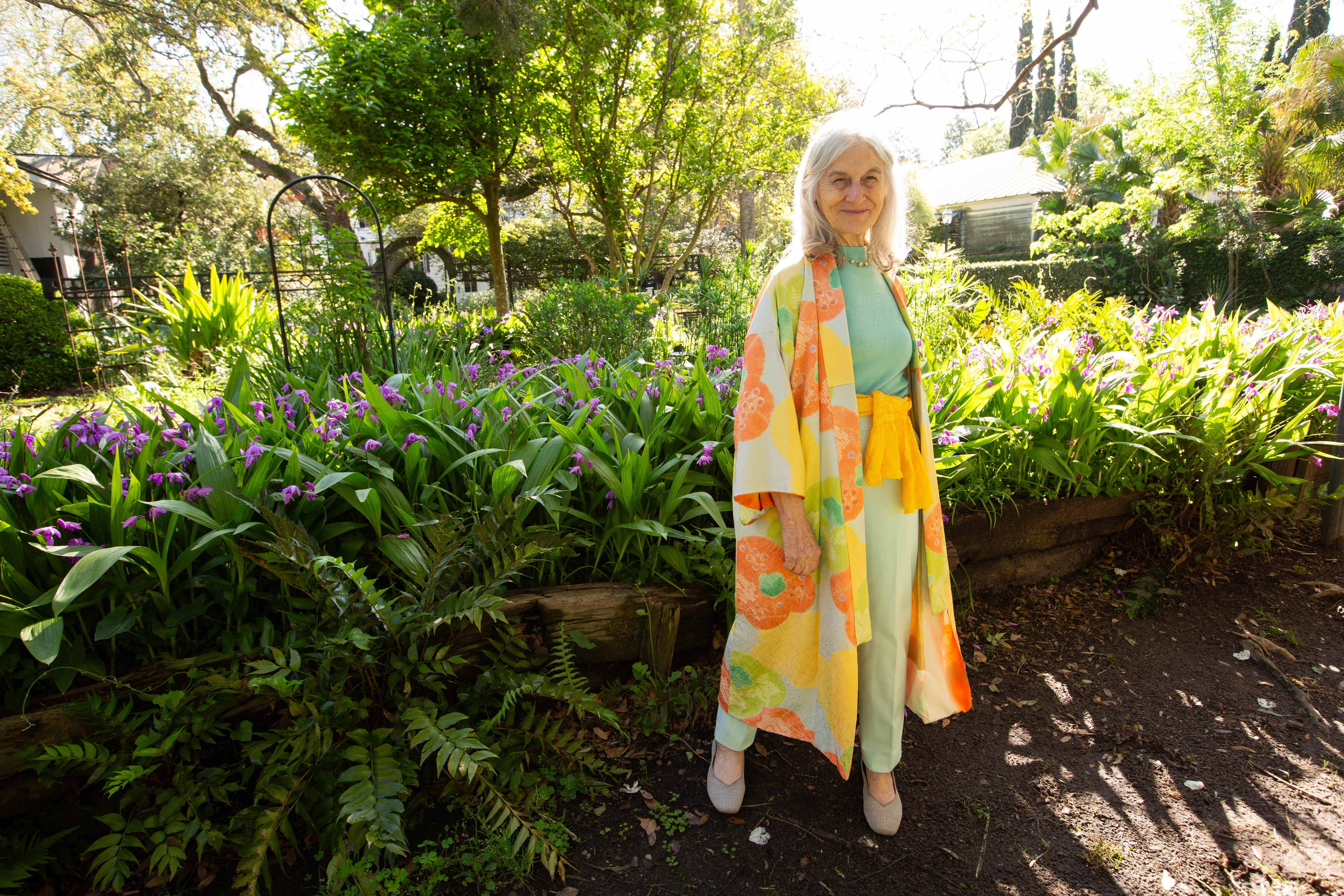 Susu owner of Kiku standing in a garden wearing a colorful outfit