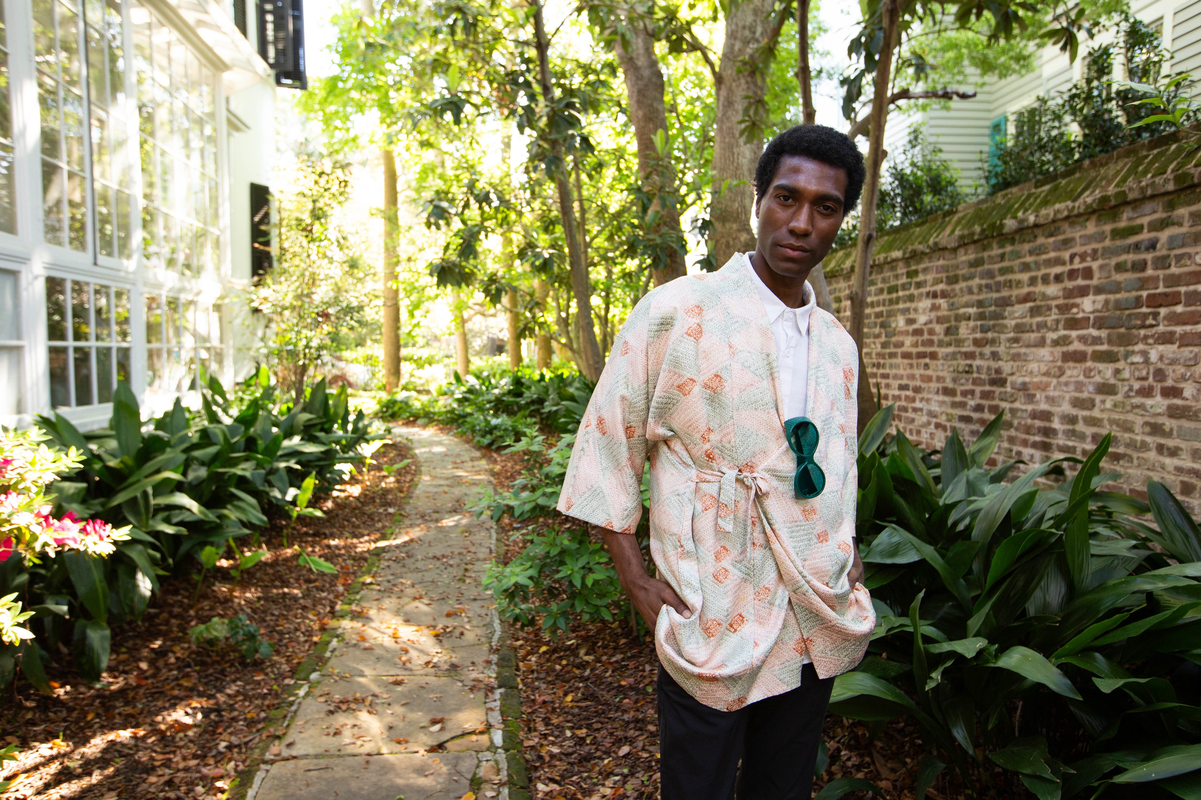 Person wearing a light-colored kimono-style garment with floral patterns in an outdoor setting.