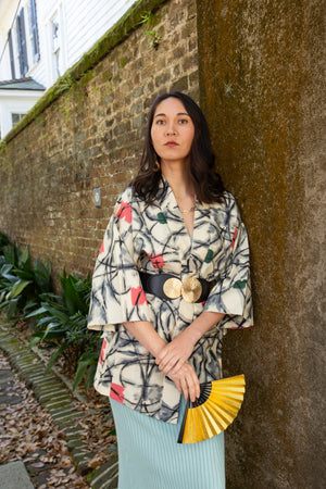 woman in black and white vintage kimono jacket with modernized sleeves holding a gold fan