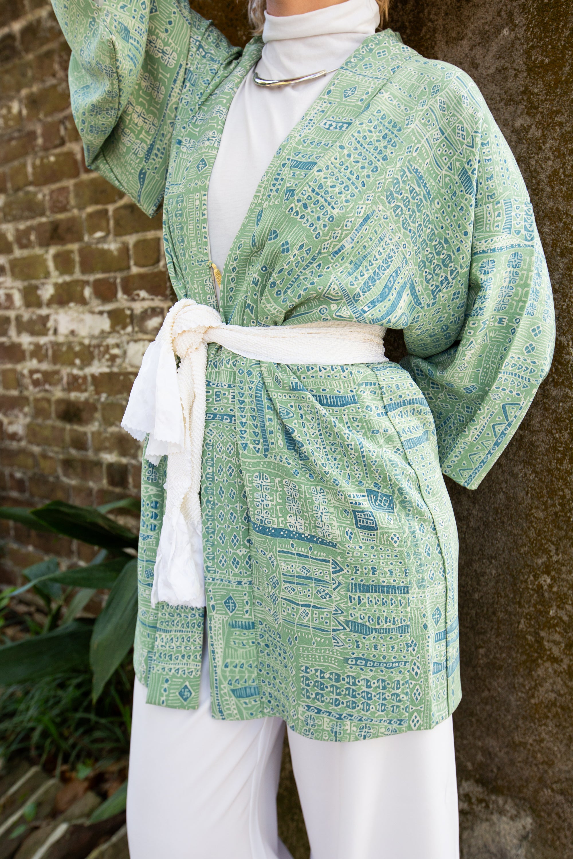 green kimono jacket on woman with white sash