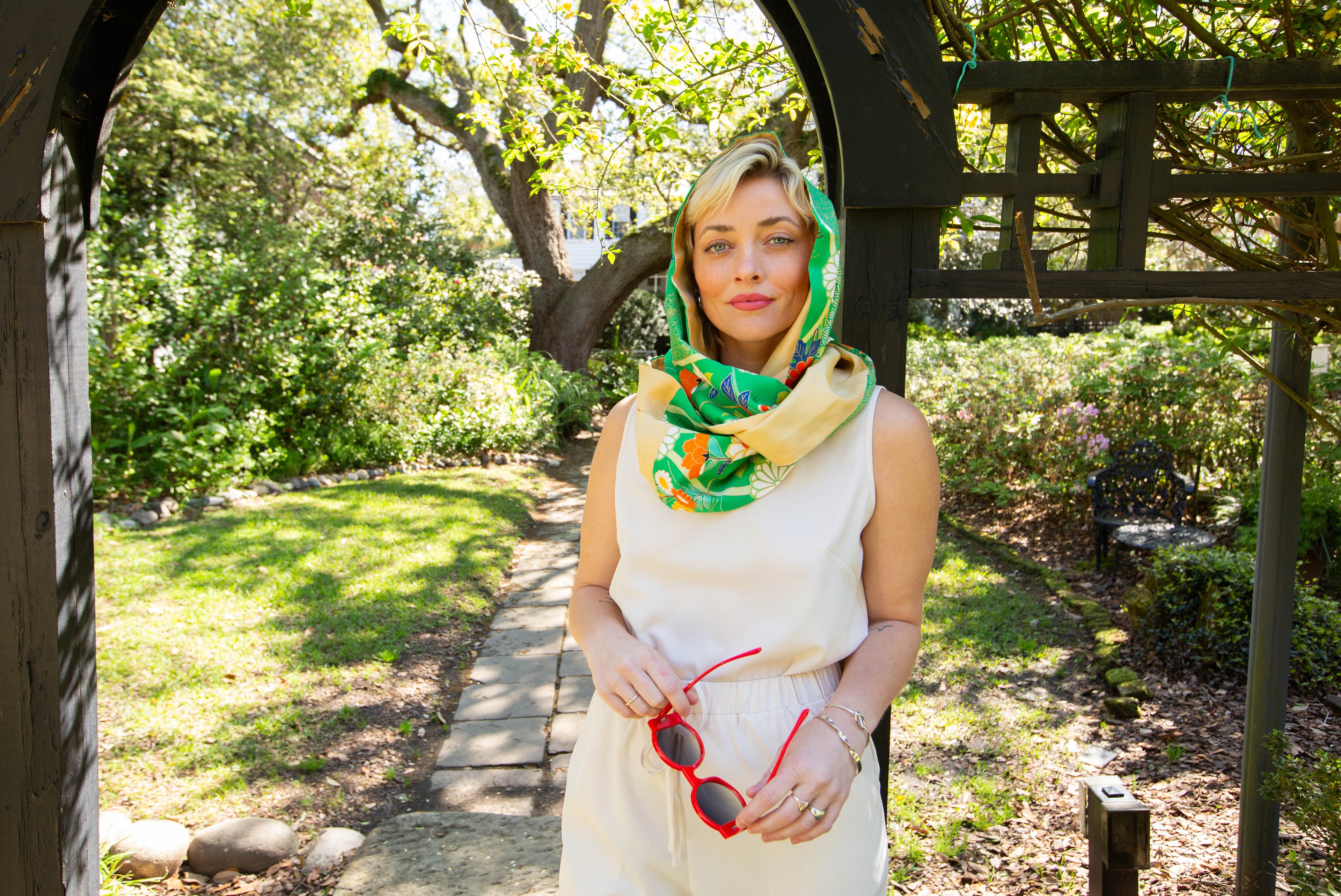 Woman with a colorful scarf standing in a garden