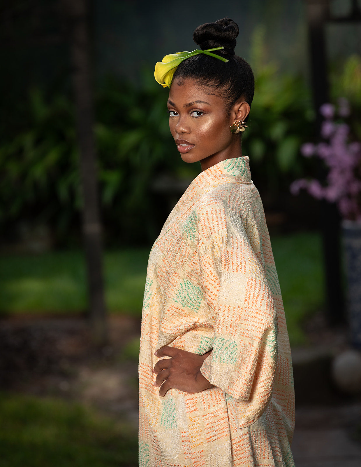 Woman in a patterned dress standing outdoors with a blurred natural background