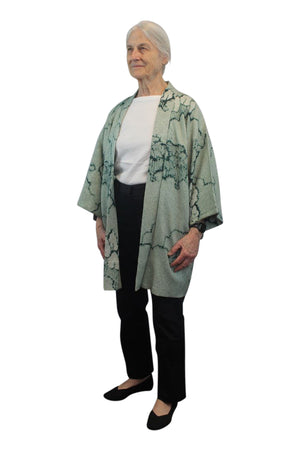 small woman in blue green kimono jacket
