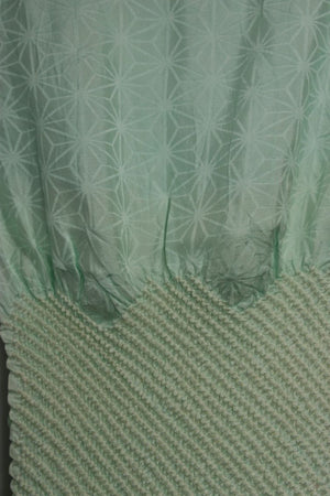 close up texture and pattern detail of the Silk sash, scarf, with pale green tie dyed design
